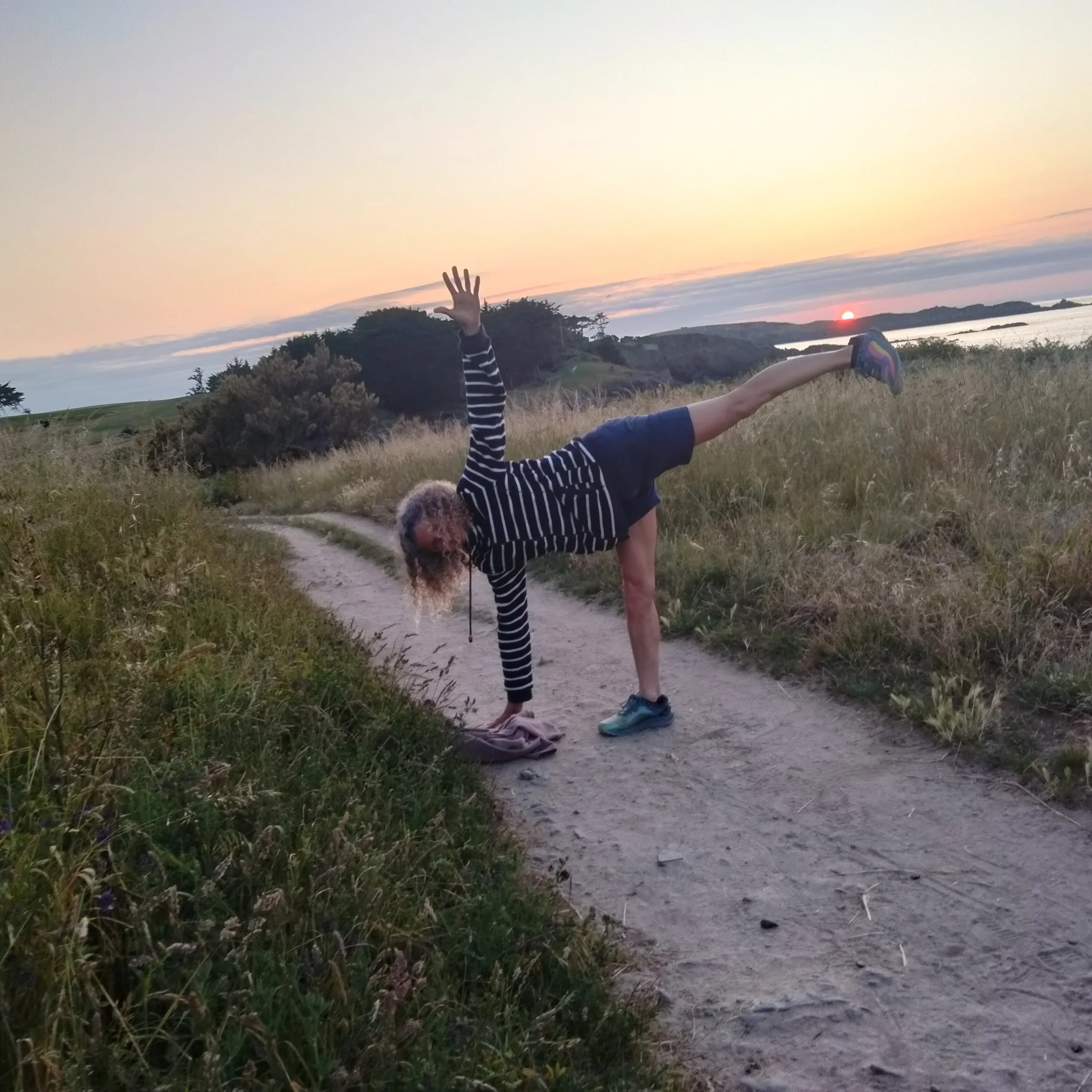 Pratique de yoga au coucher de soleil sur la côte bretonne, posture en équilibre en pleine nature face à l’océan, idéale pour une retraite yoga à Saint-Briac-sur-Mer.
