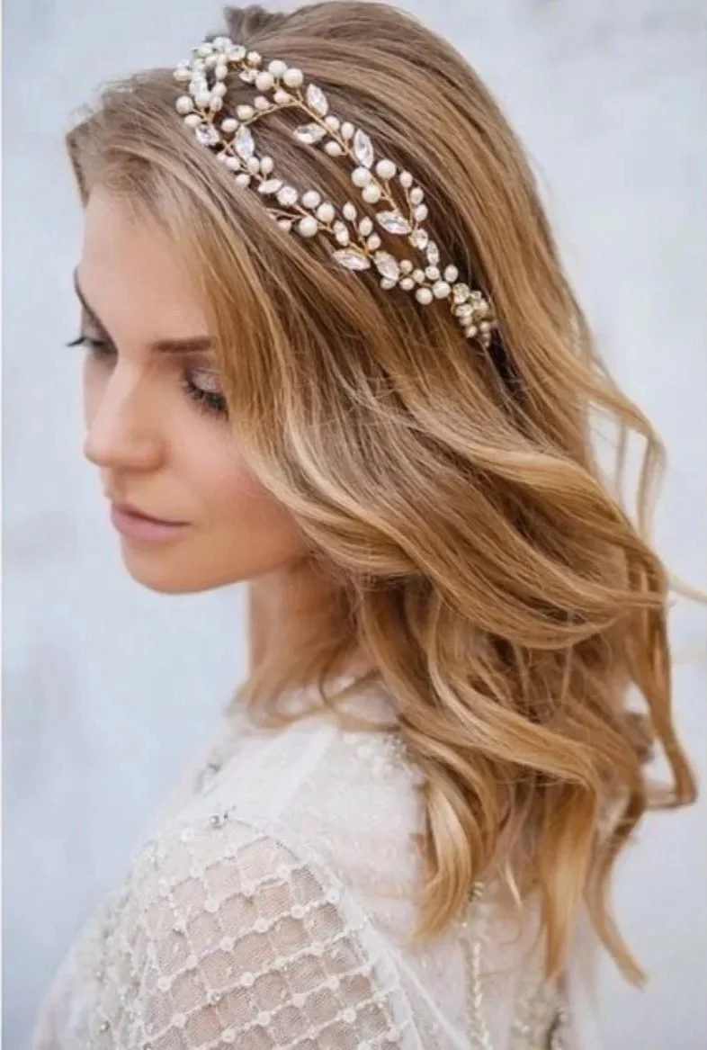 Side profile of a woman with wavy, light brown hair wearing a pearl and crystal headband.