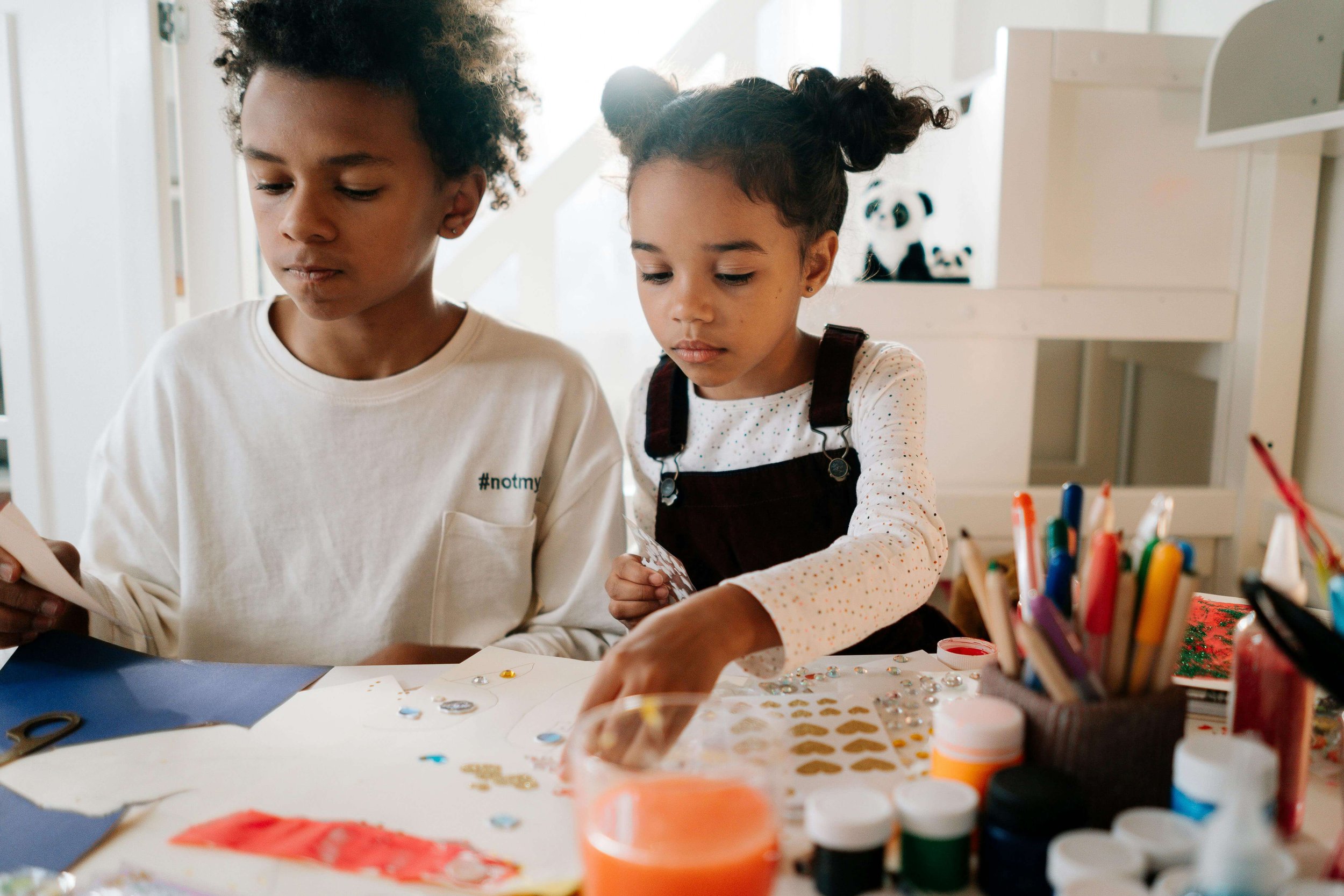 Children engaged in a creative art activity together, illustrating how art can support emotional expression when working with a grief therapist for pet loss in Sacramento, CA.