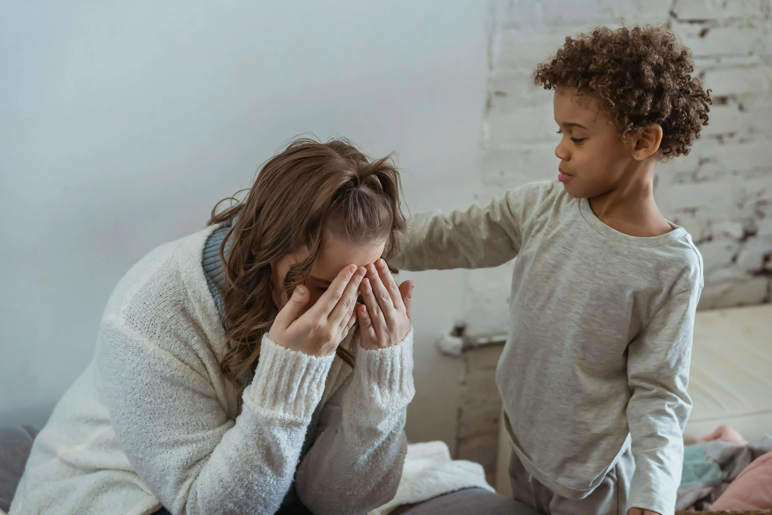 Child offering comfort to a grieving parent at home, reflecting the emotional complexity of parenting while grieving in Sacramento, CA.