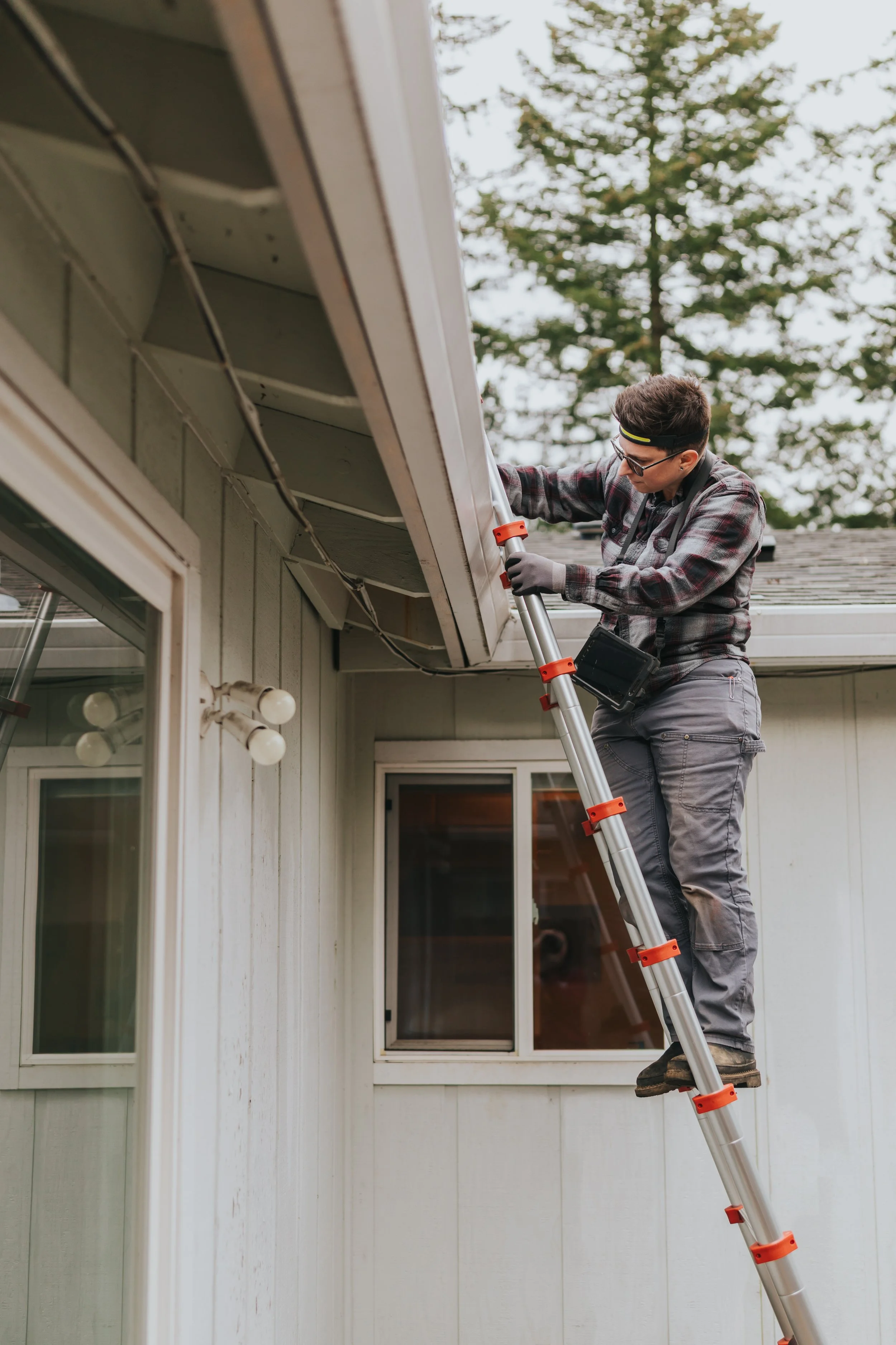 Marissa Longpeak, inspector is looking at the gutter of a house.