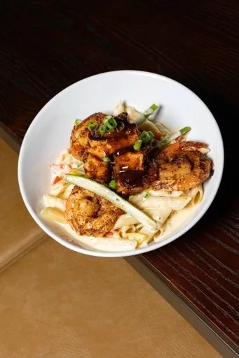 Bowl of fried chicken wings with green onions and noodles