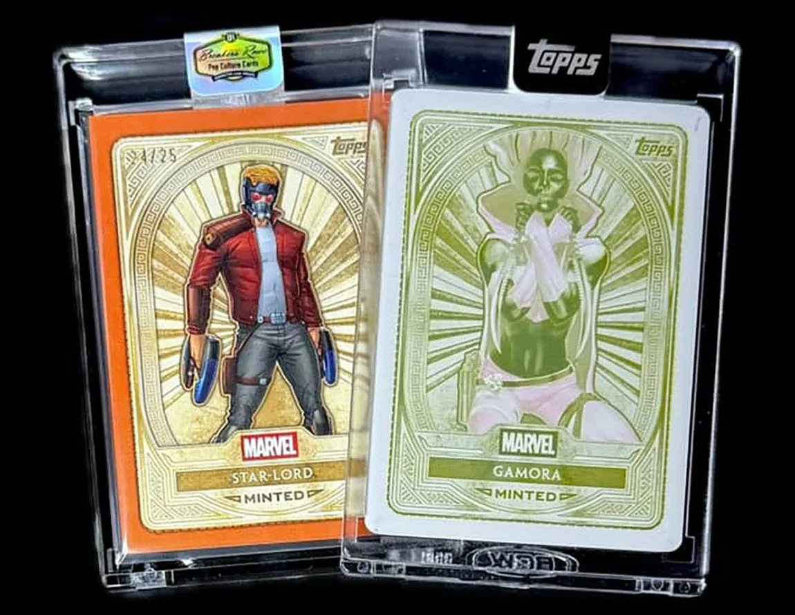 Two Marvel-themed collectible cards, one featuring Star-Lord in a red jacket wearing a mask, and the other featuring Gamora with green skin, seated on a throne, both in gold-illustrated card designs, housed in plastic cases.
