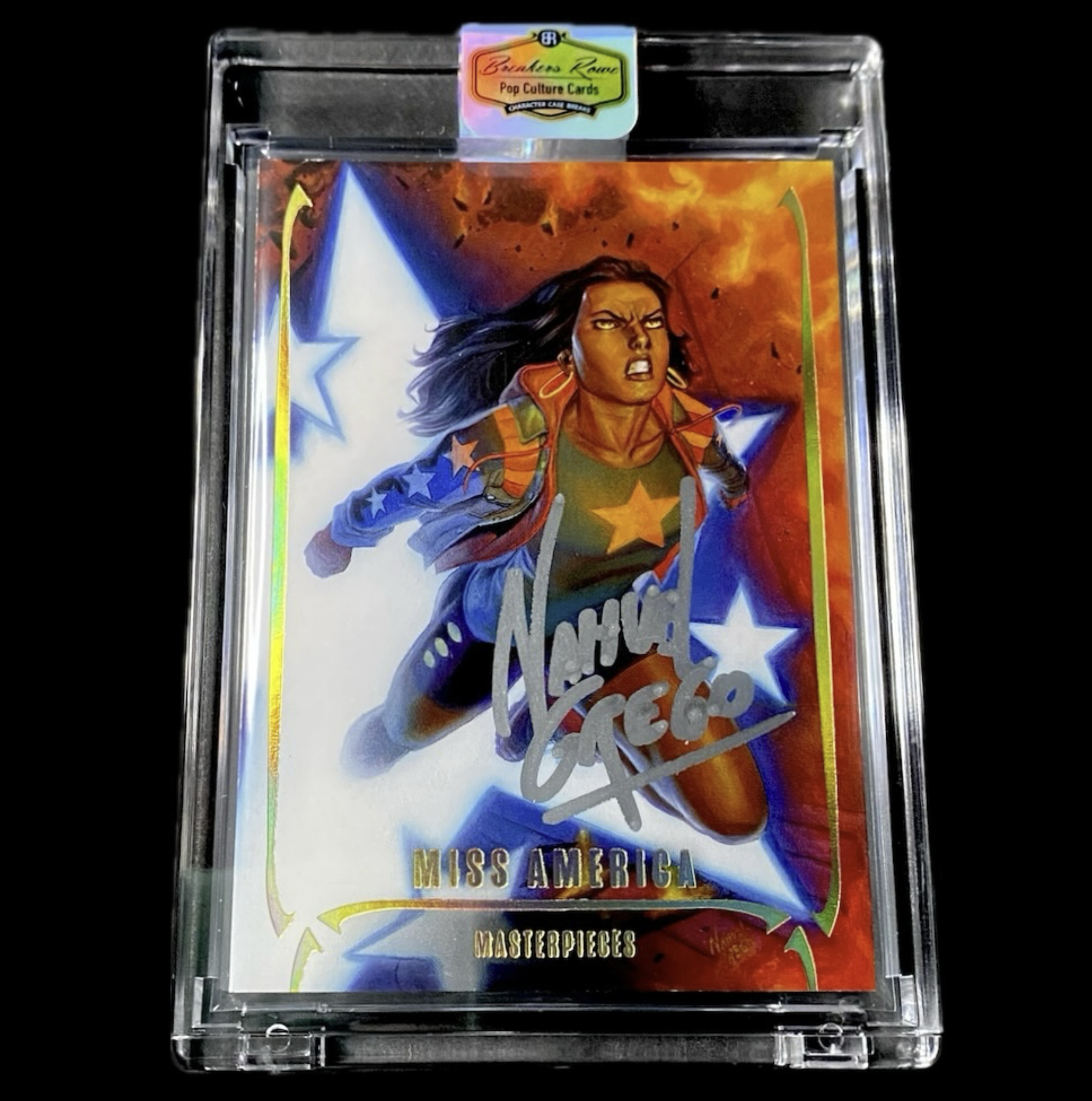 Silver framed trading card showcasing a dynamic illustration of Miss America, a Marvel character with dark hair, wearing a superhero costume with stars, against a fiery background. The card has an autograph across the front and the label at the top r