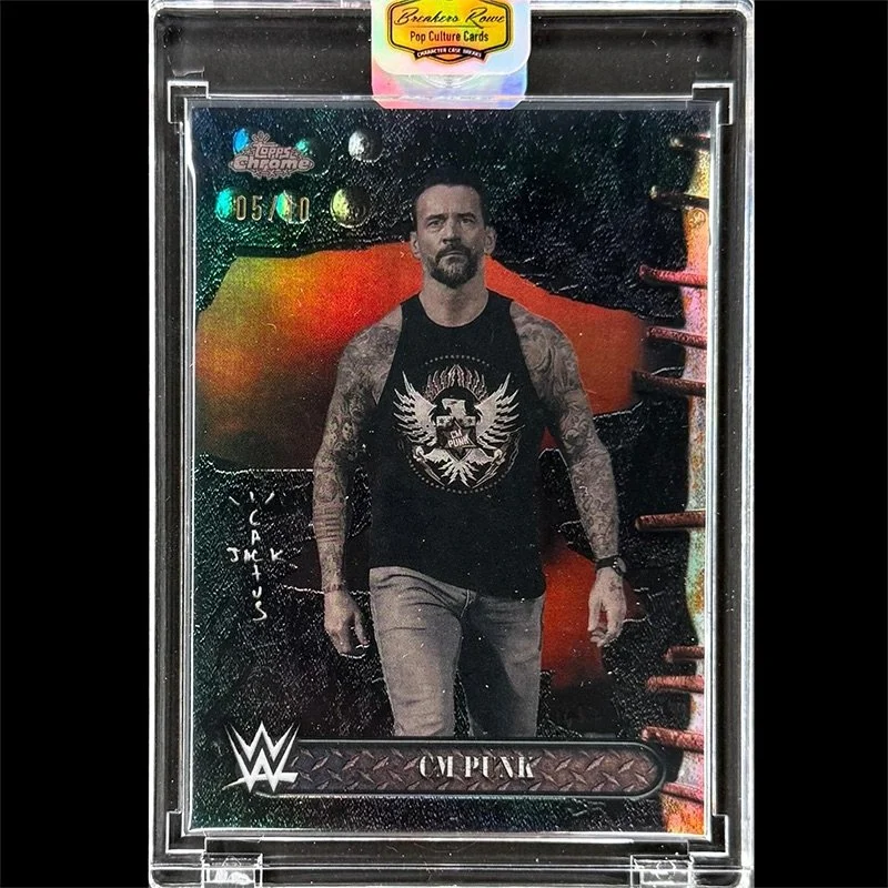 WWE Topps Chrome football card featuring a photo of CM Punk with tattoos, wearing a black tank top with a gothic graphic, standing in front of a colorful, abstract background, encased in a protective plastic case.