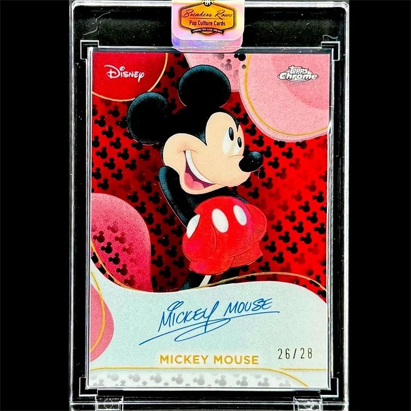 A collectible trading card featuring Mickey Mouse from Disney, with Mickey smiling and wearing red shorts and large yellow shoes. The card is labeled as a Topps Chrome Pop Culture Card, numbered 26 out of 28, and has Mickey Mouse's signature on it.