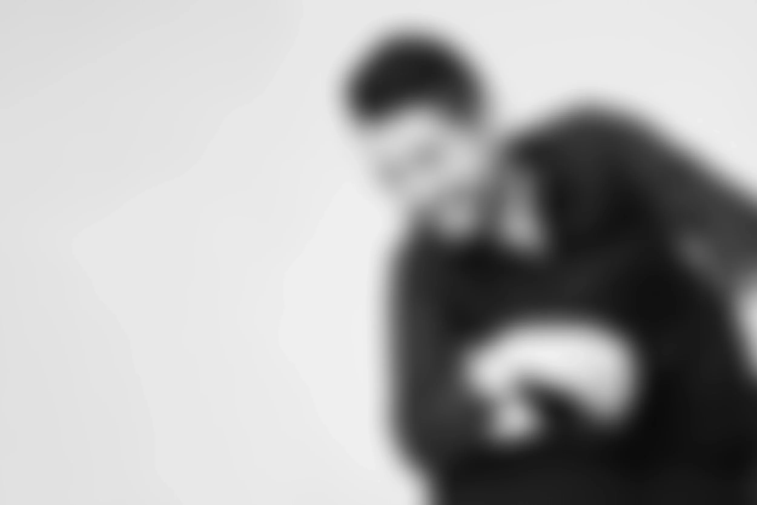 Persona con gafas, cabello oscuro, sonriendo, en un fondo blanco.