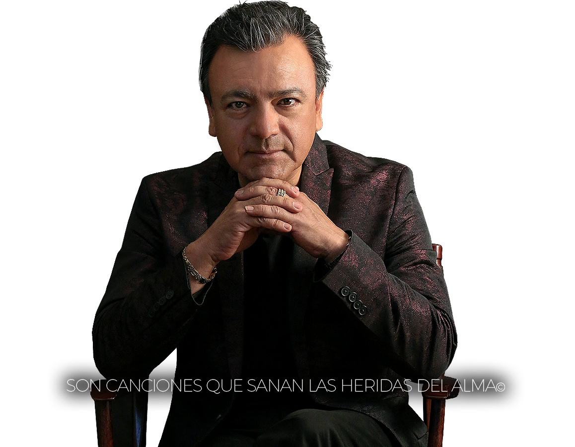 Hombre con cabello gris, sentado en una silla con manos entrelazadas, lleva una chaqueta oscura y mira hacia adelante con expresión seria. Texto en la imagen dice: "SON CANCIONES QUE SANAN LAS HERIDAS DEL ALMA".