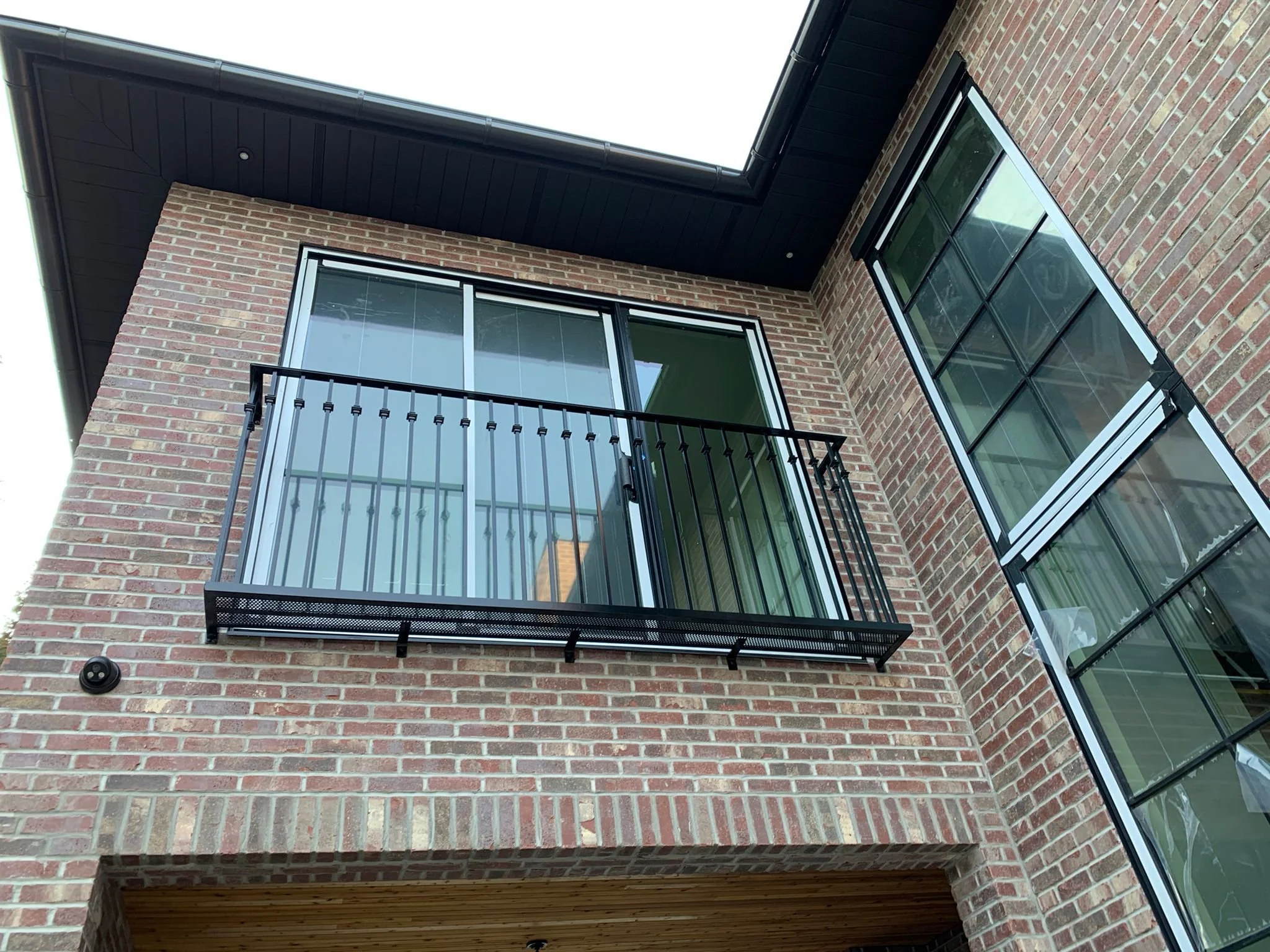 Modern balcony with black metal railing and architectural exterior detailing
