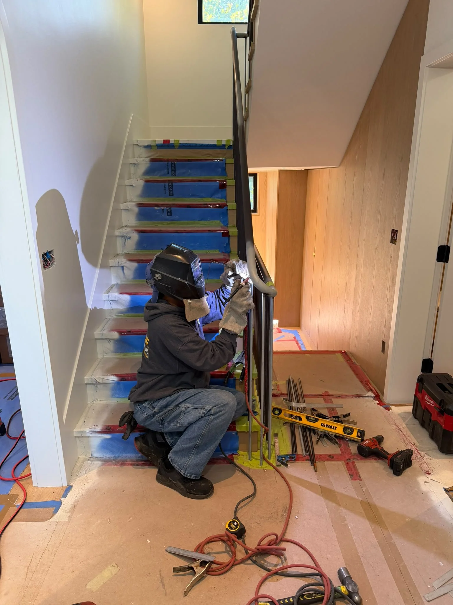 Iron Age installer fitting a custom interior stair railing on site
