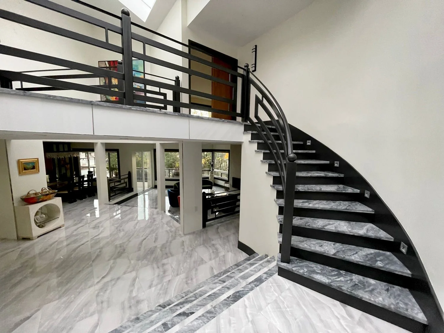 Curved staircase with custom black metal railing Vancouver luxury home