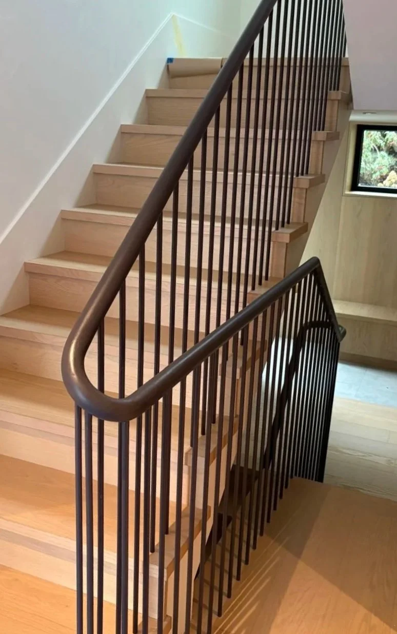 Custom black steel railing on a modern interior staircase in Vancouver