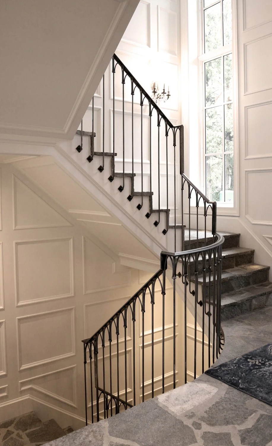 Modern black iron staircase railing with wood stairs in luxury home