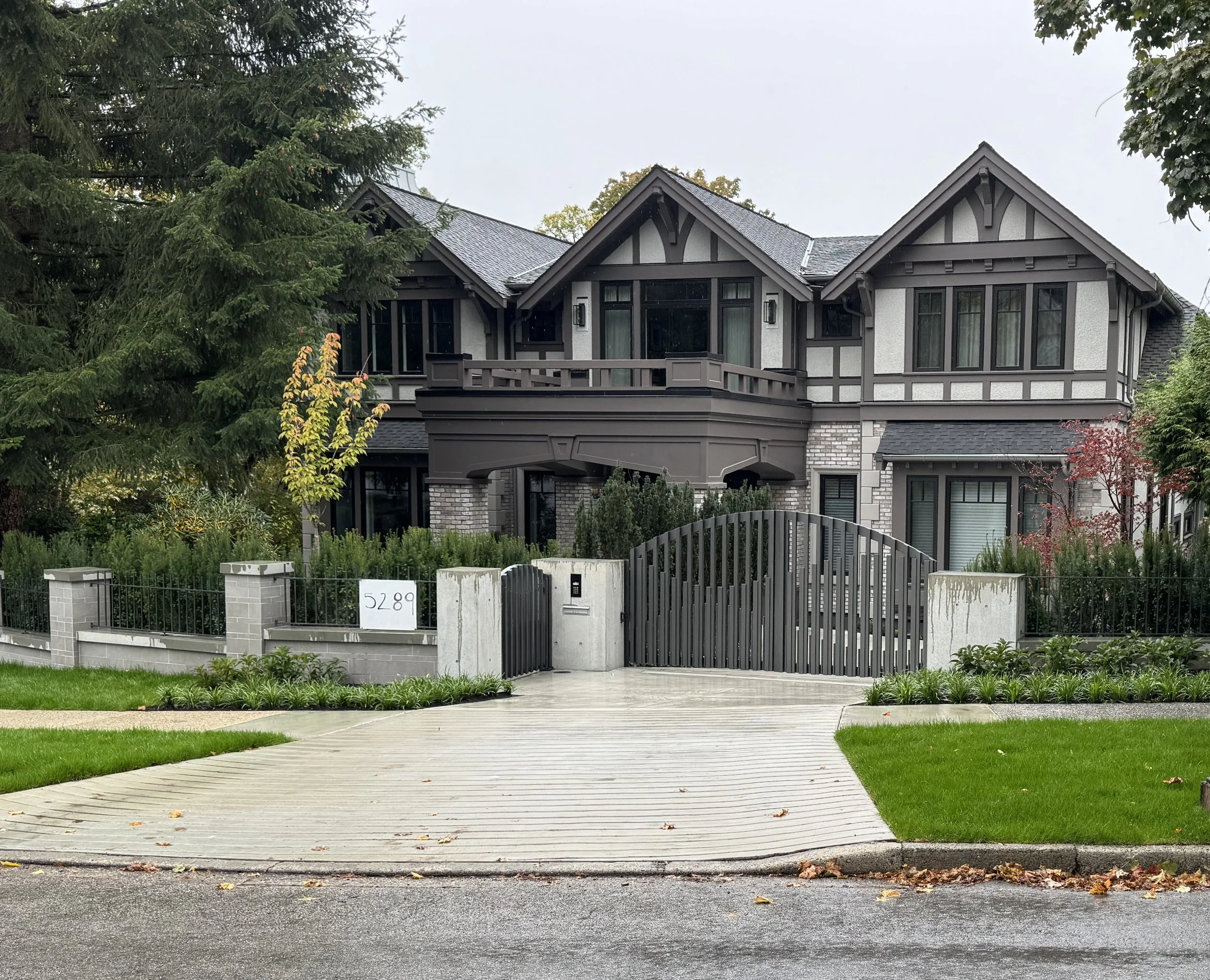 Luxury custom home exterior with architectural metalwork and modern driveway