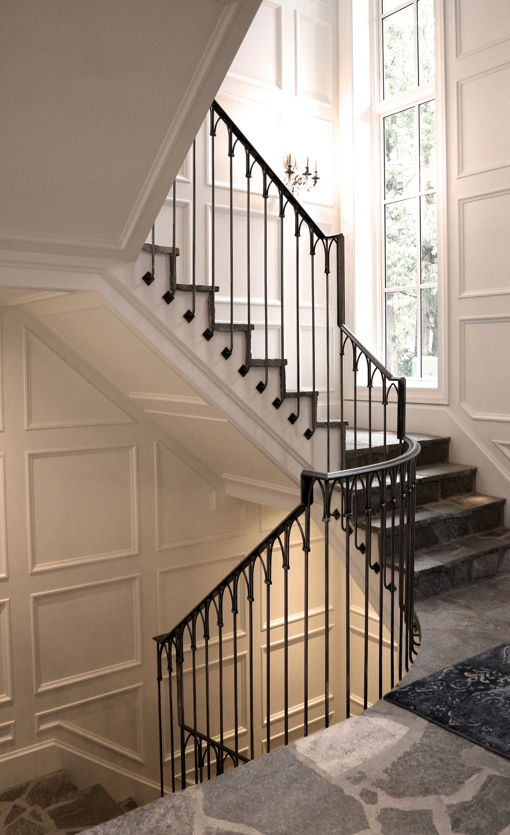 Interior staircase with custom black wrought iron railing fabricated by Iron Age in Vancouver