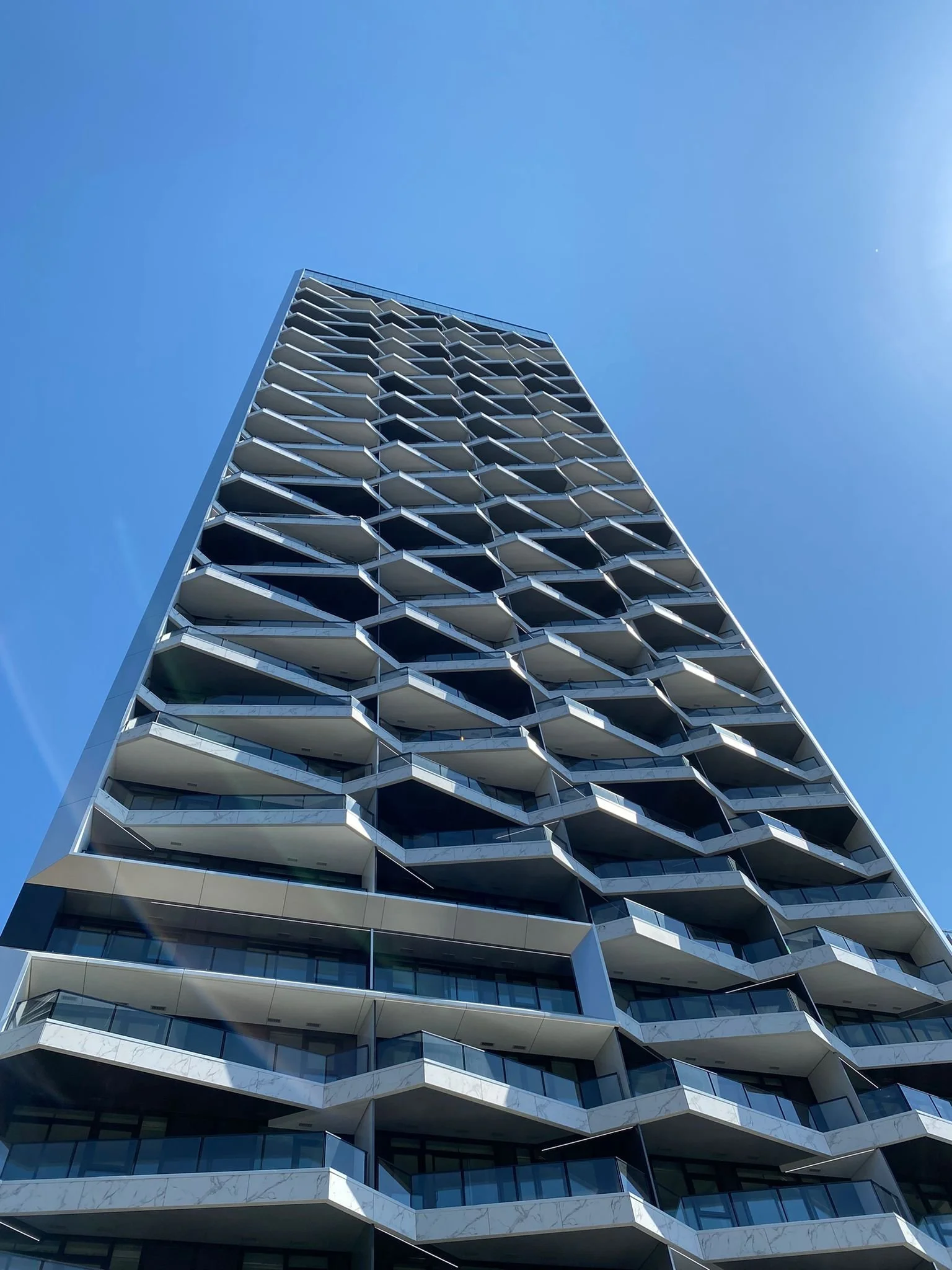 High-rise building with modern glass balcony railings and architectural exterior