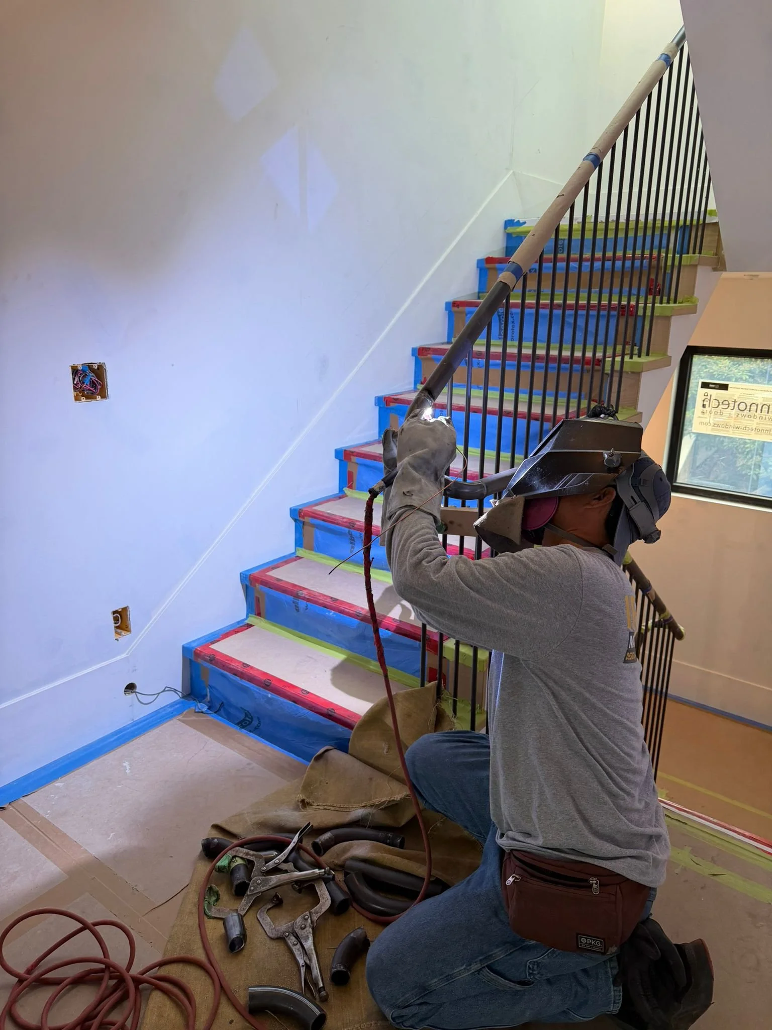 On-site welding of a custom curved handrail for an interior staircase