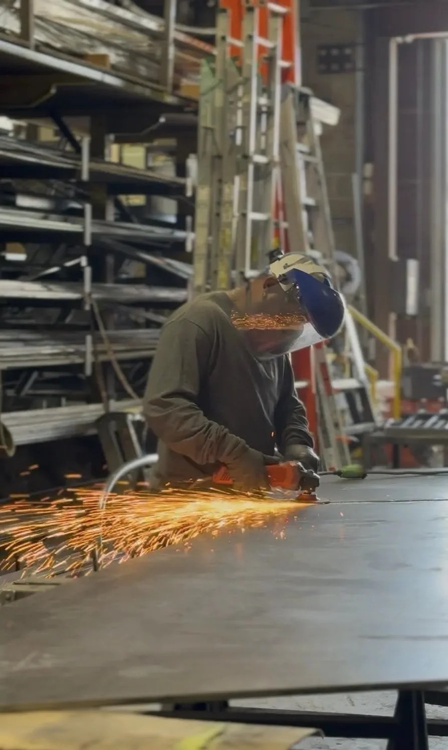 Welder assembling a custom metal railing in the Iron Age fabrication shop