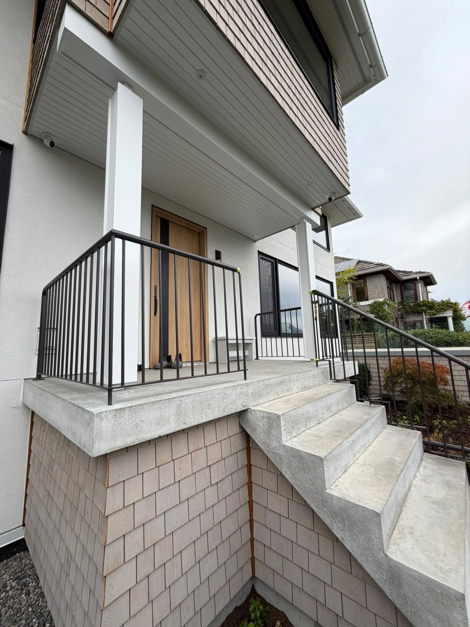 Completed black metal railings at the front entrance of a modern home