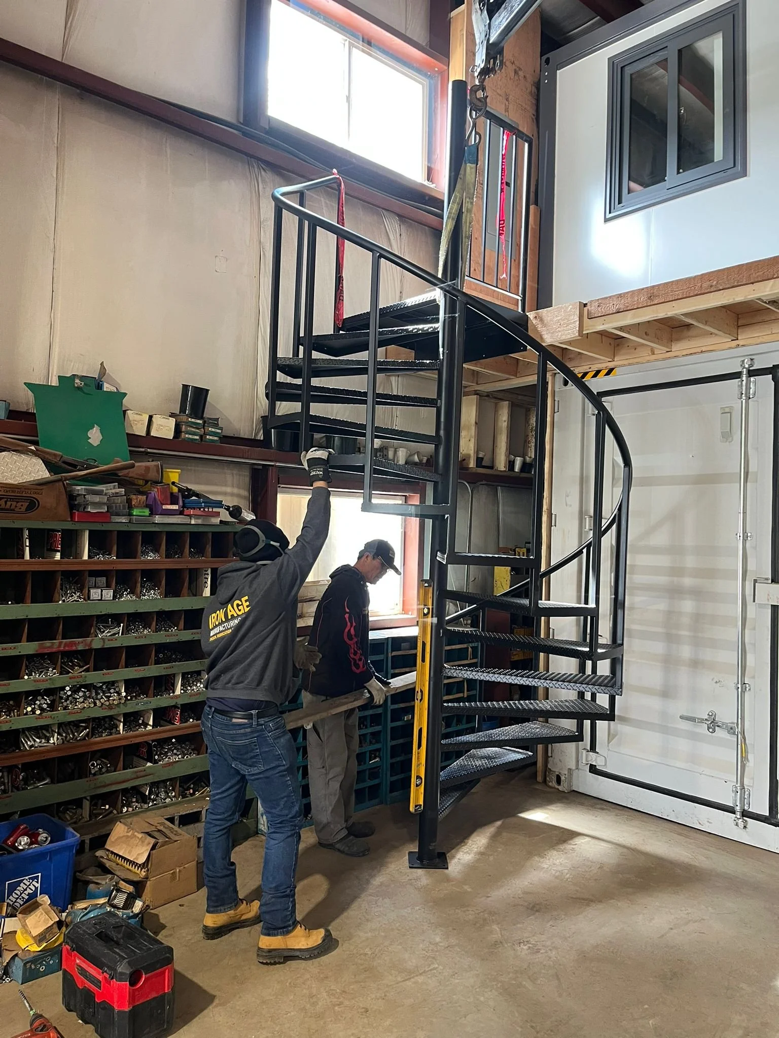 Black metal spiral staircase with custom railing, designed and fabricated by Iron Age for a modern Vancouver interior.