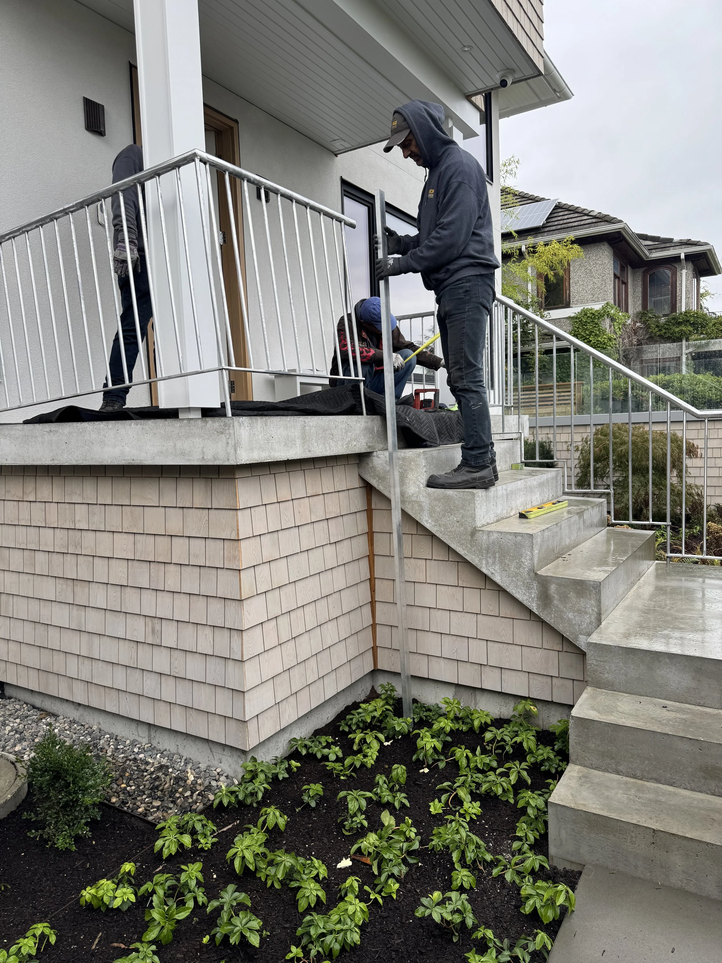 Iron Age crew installing custom exterior railings at a Vancouver residence