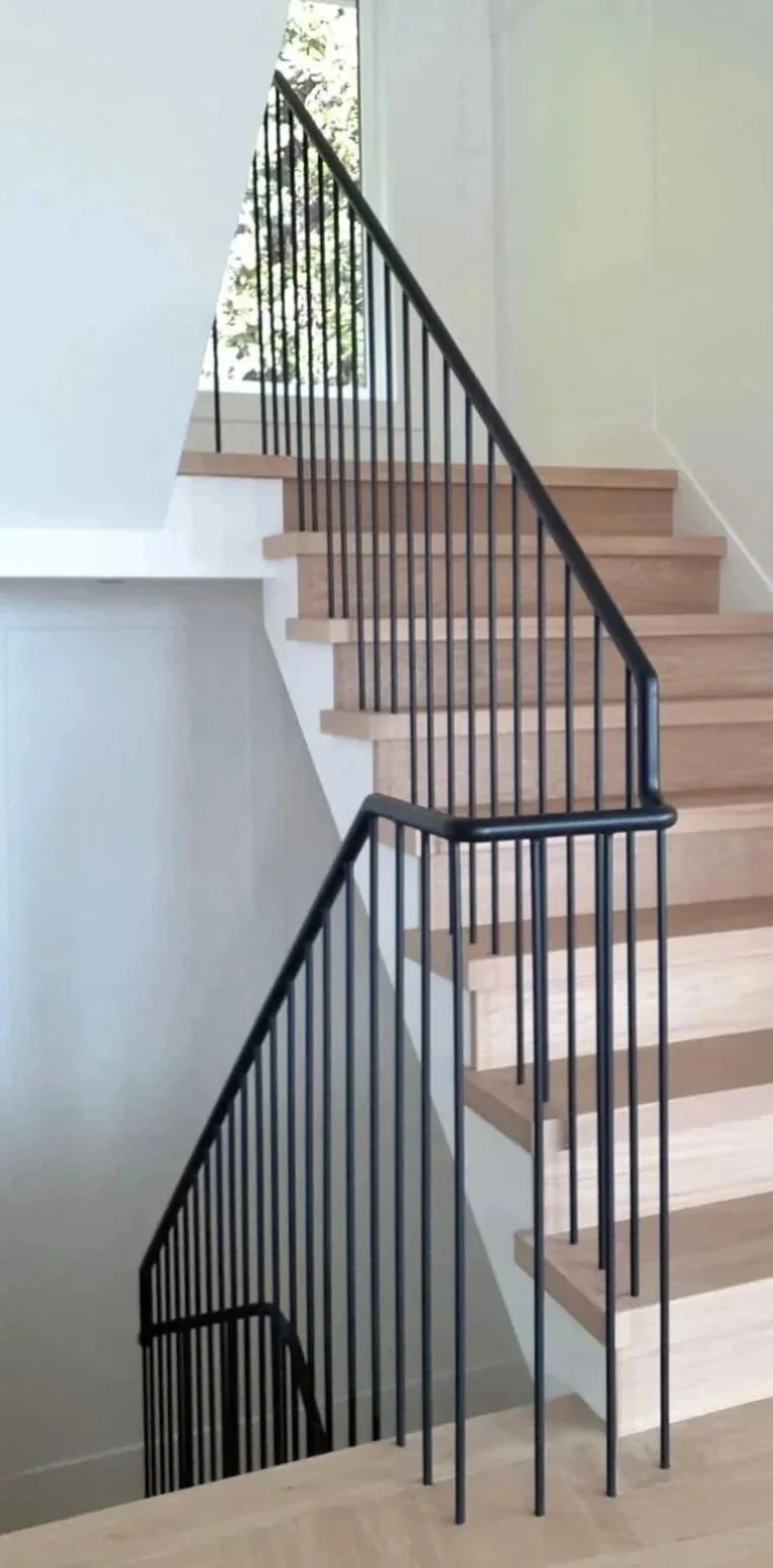 Interior staircase with wood steps and custom metal railing in Vancouver home