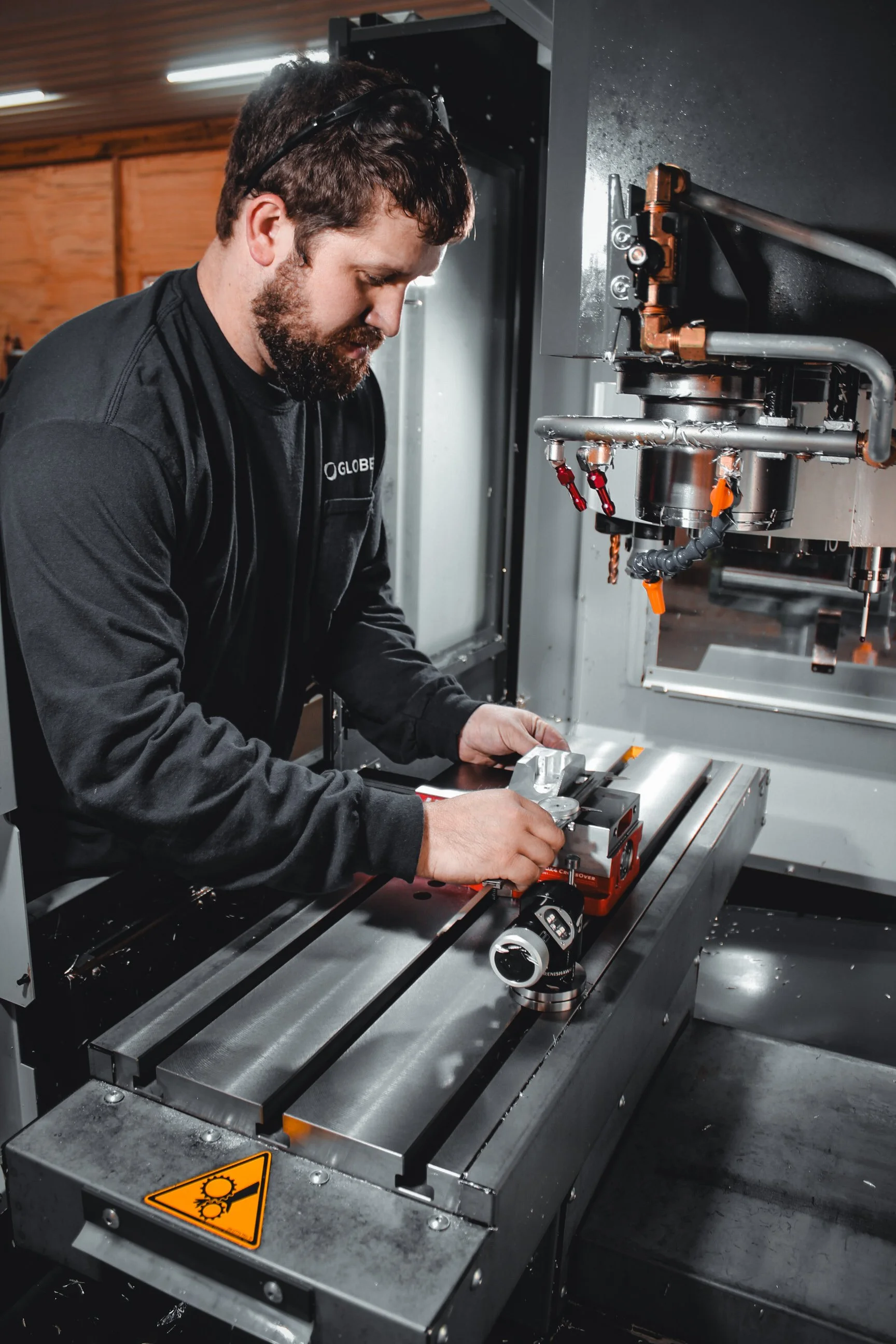 A man working on a CNC machine in an industrial setting.