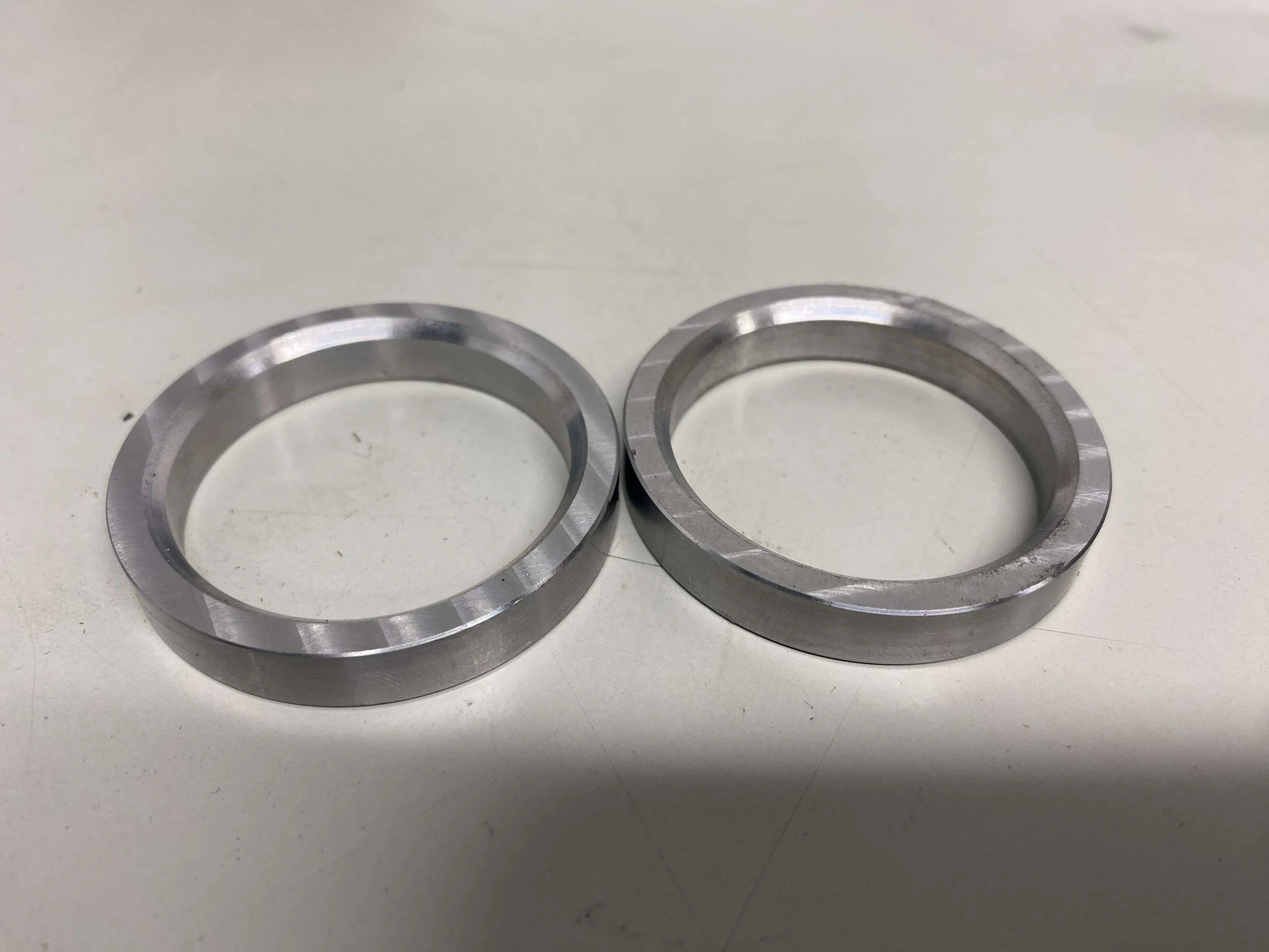 Two silver metal rings placed on a white surface.