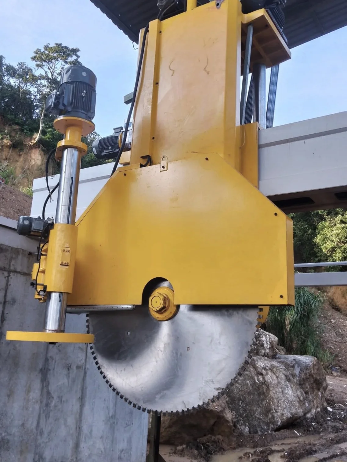 Large industrial concrete saw cutting through rock outdoors to process limestone