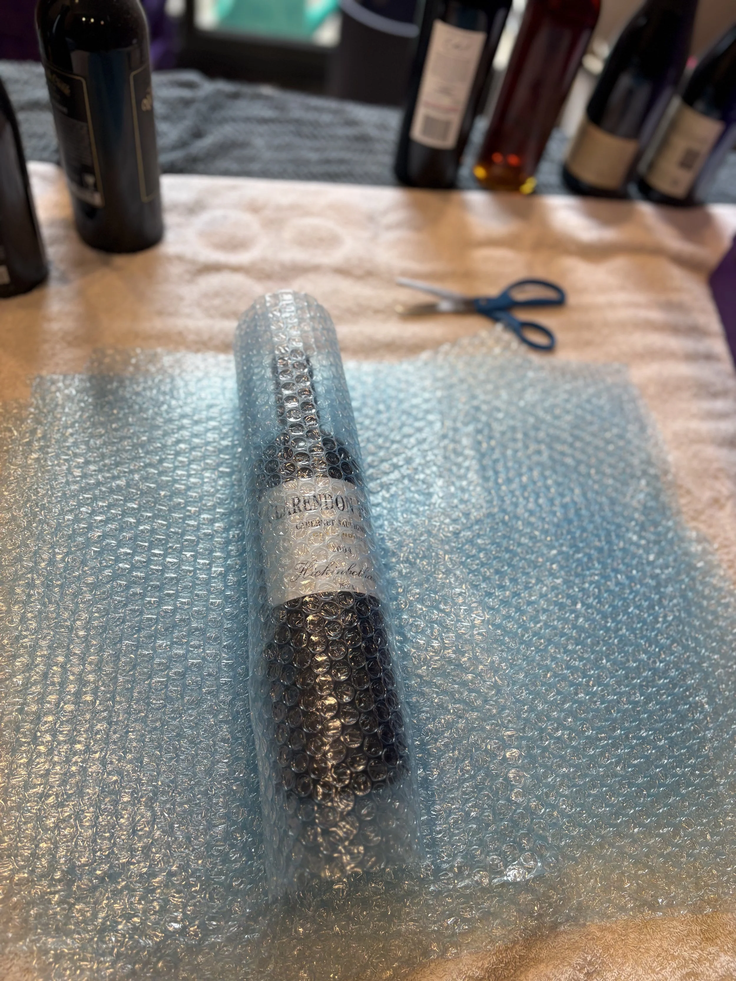 Stacks of purple plastic tubs labeled 'ecotub' at 'Cool Cat Removals' warehouse with a logo of a cat wearing sunglasses on the wall.