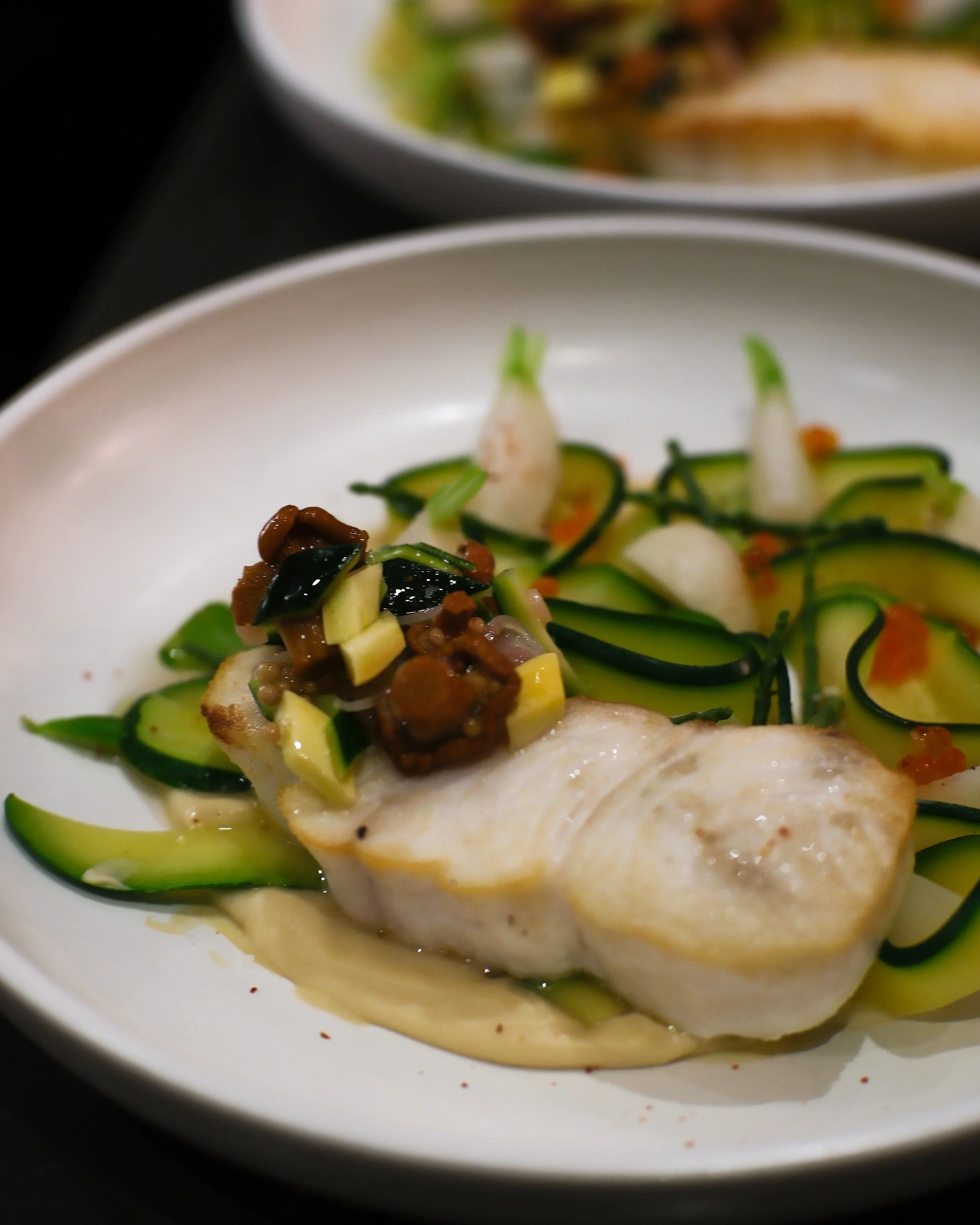 Flétan, purée de céléri-rave, courgettes braisées, beurre blanc aux coquillages, chanterelles marinées.