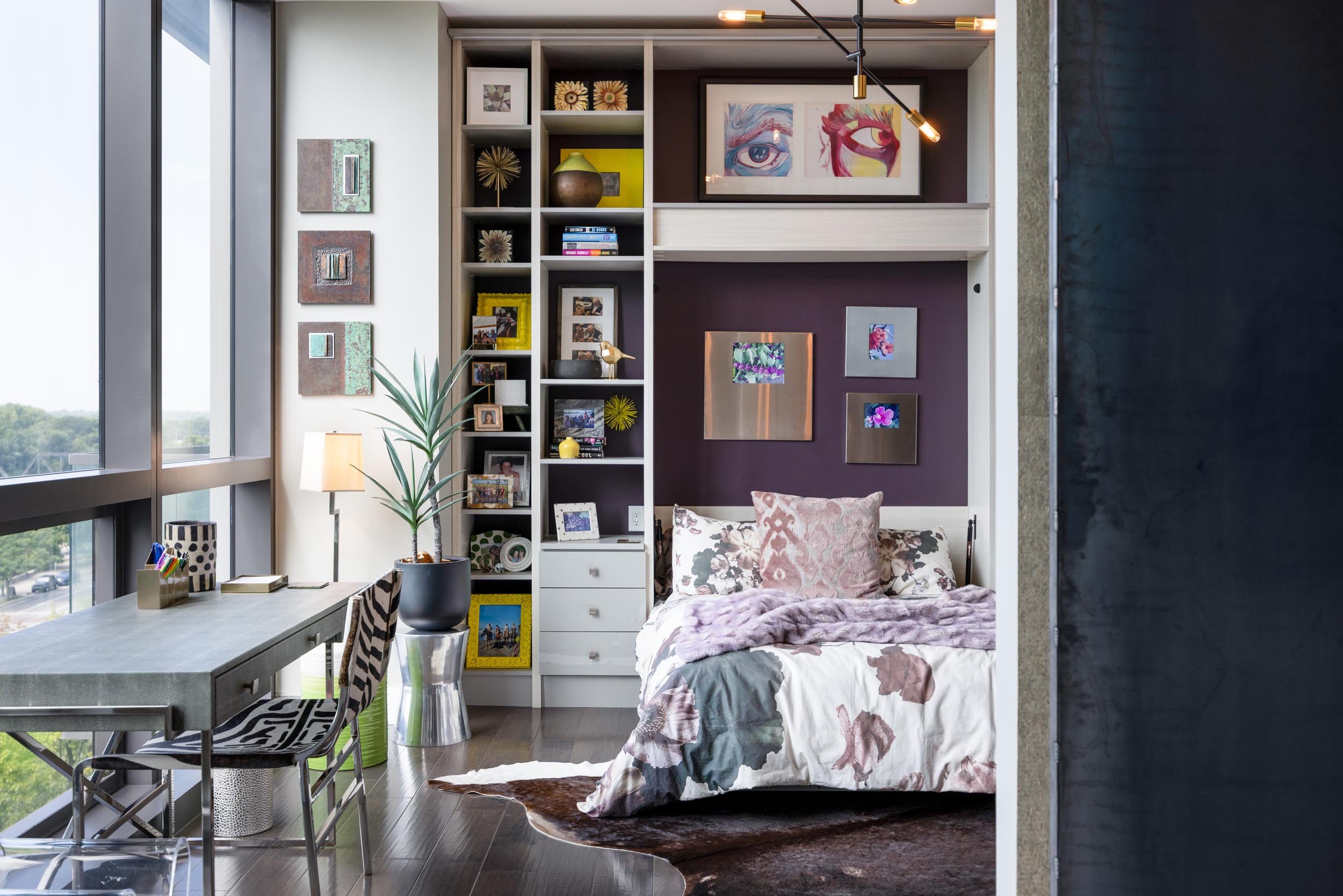A modern bedroom with a custom built Murphy bed and custom built-in shelving showcasing books and decor in Columbus, Ohio.