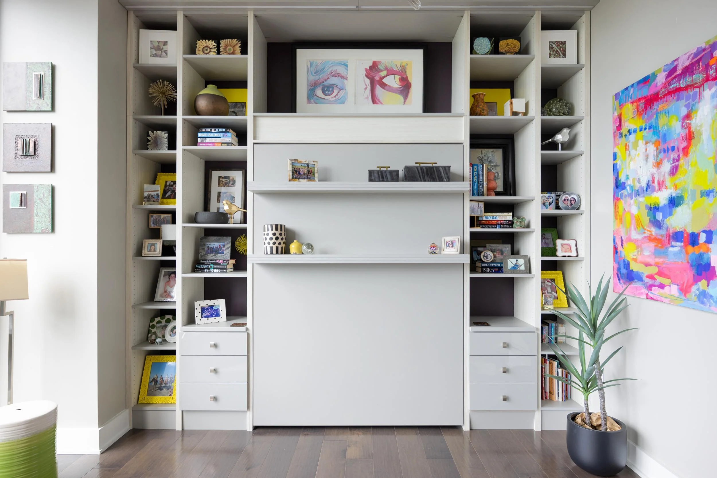 Decorative white built-in bookshelf and custom made Murphy bed in Columbus, Ohio.