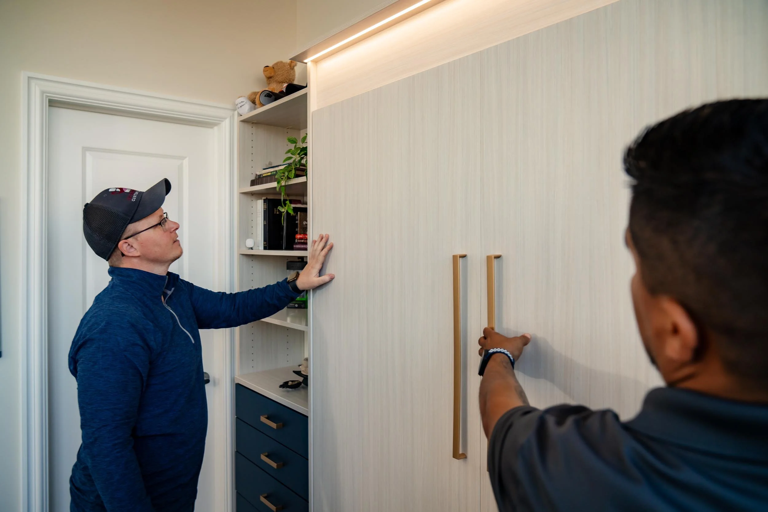 Elevate Outfitters working to install a custom-built Murphy bed with built-in bedroom shelving and storage in Columbus, Ohio.
