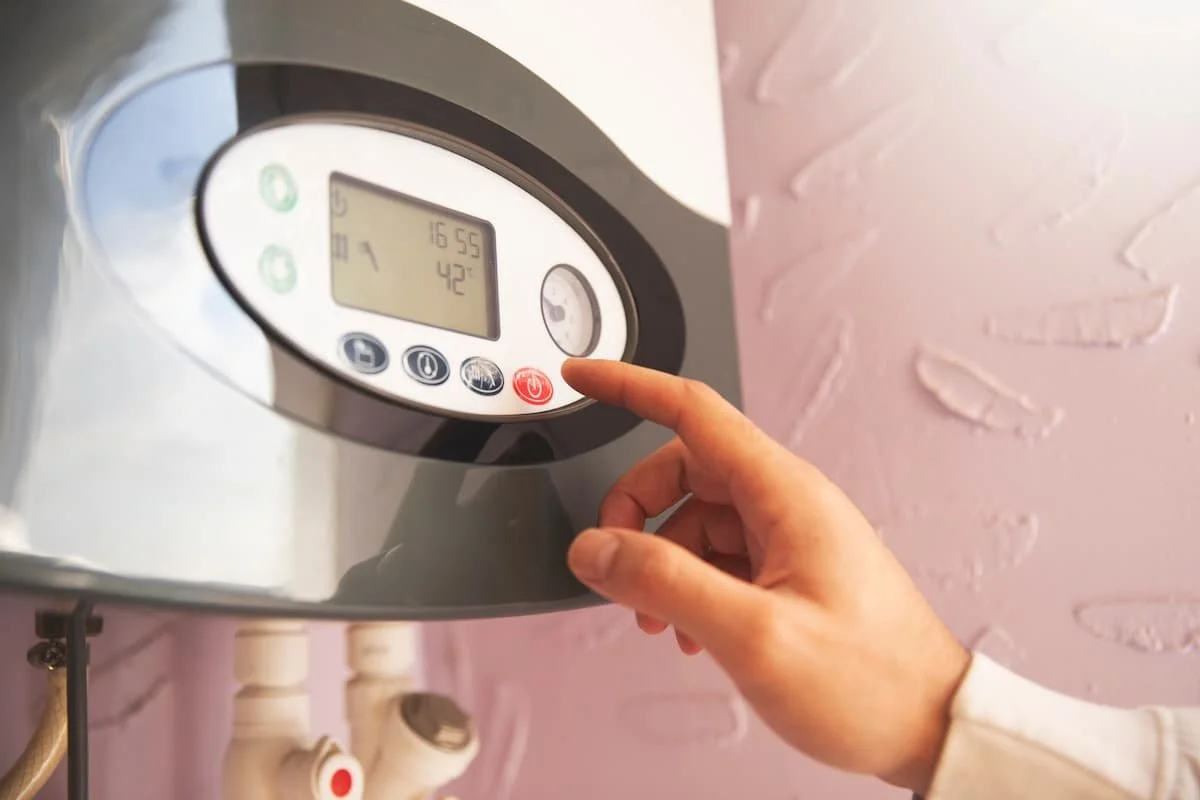 Homeowner adjusting the temperature settings on a high-efficiency tankless water heater system.