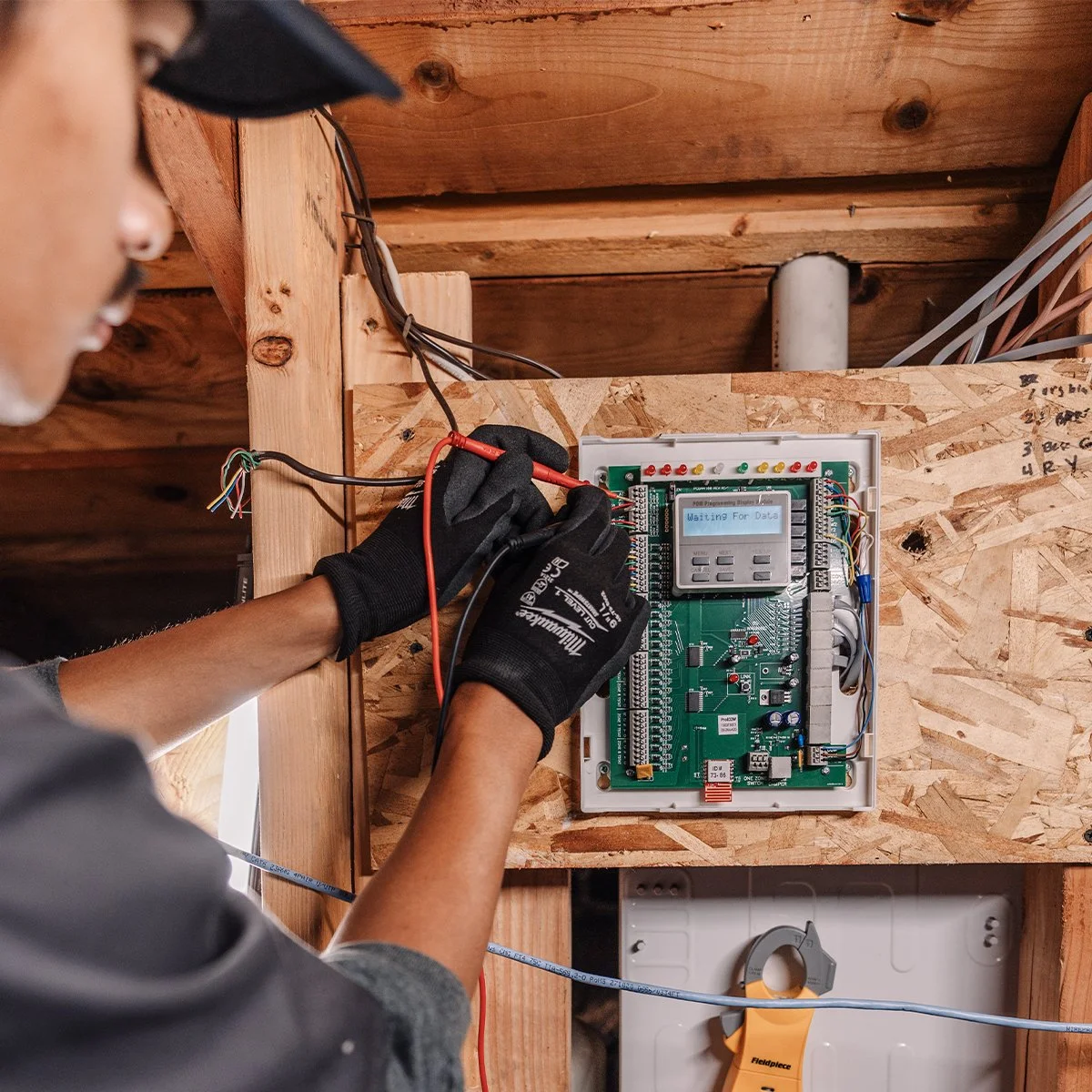 Professional electrician installing and testing an electrical control panel system