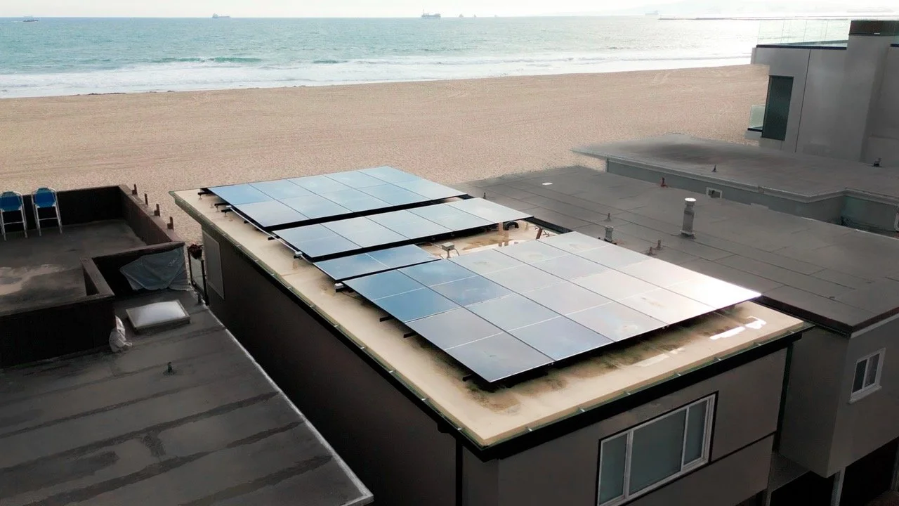 econo air solar panels on a Newport Beach home with the empty beach ocean and sunset in the background
