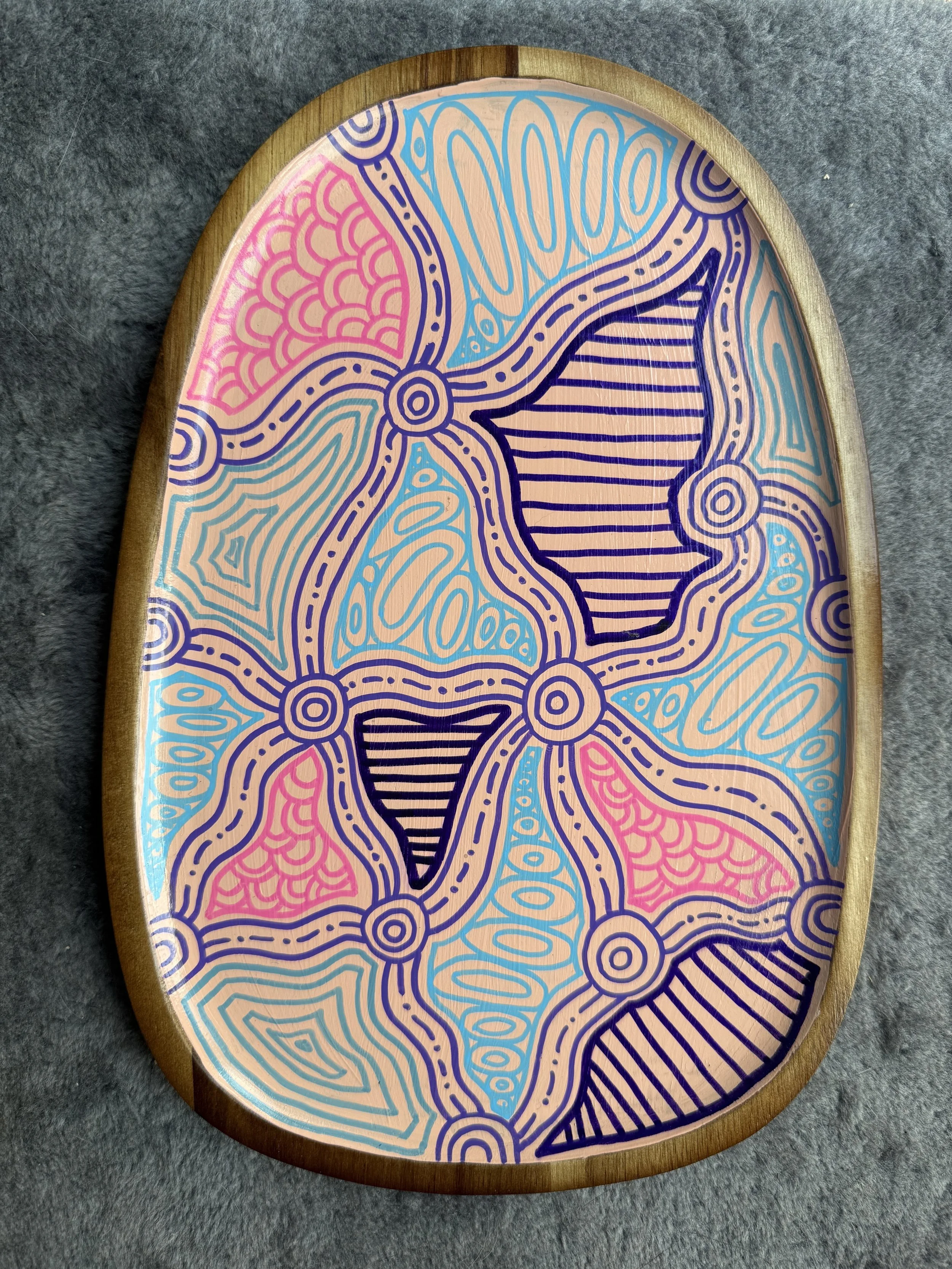 Decorative wooden tray with colorful abstract patterns in pink, blue and purple.