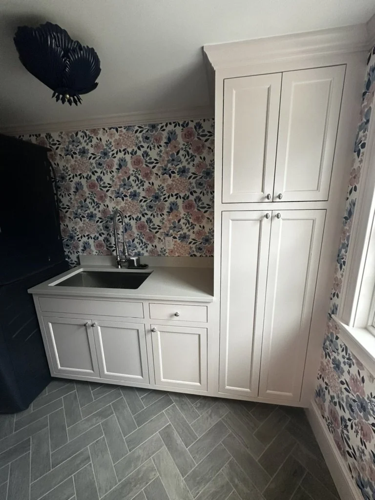 A white vanity featuring storage and a sink.