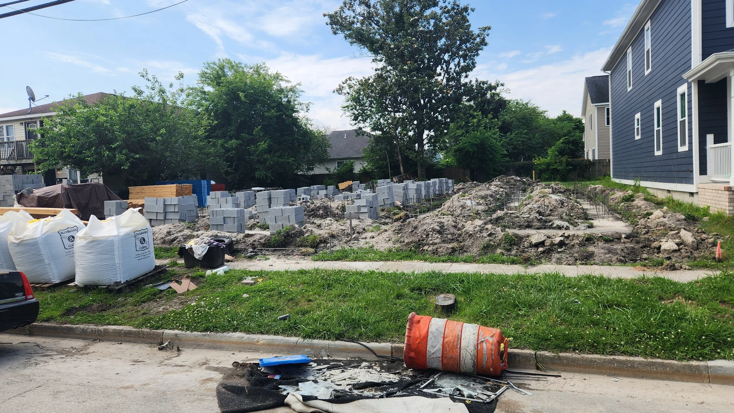 Construction site with a foundation of concrete blocks being constructed and pallets of supplies on site.