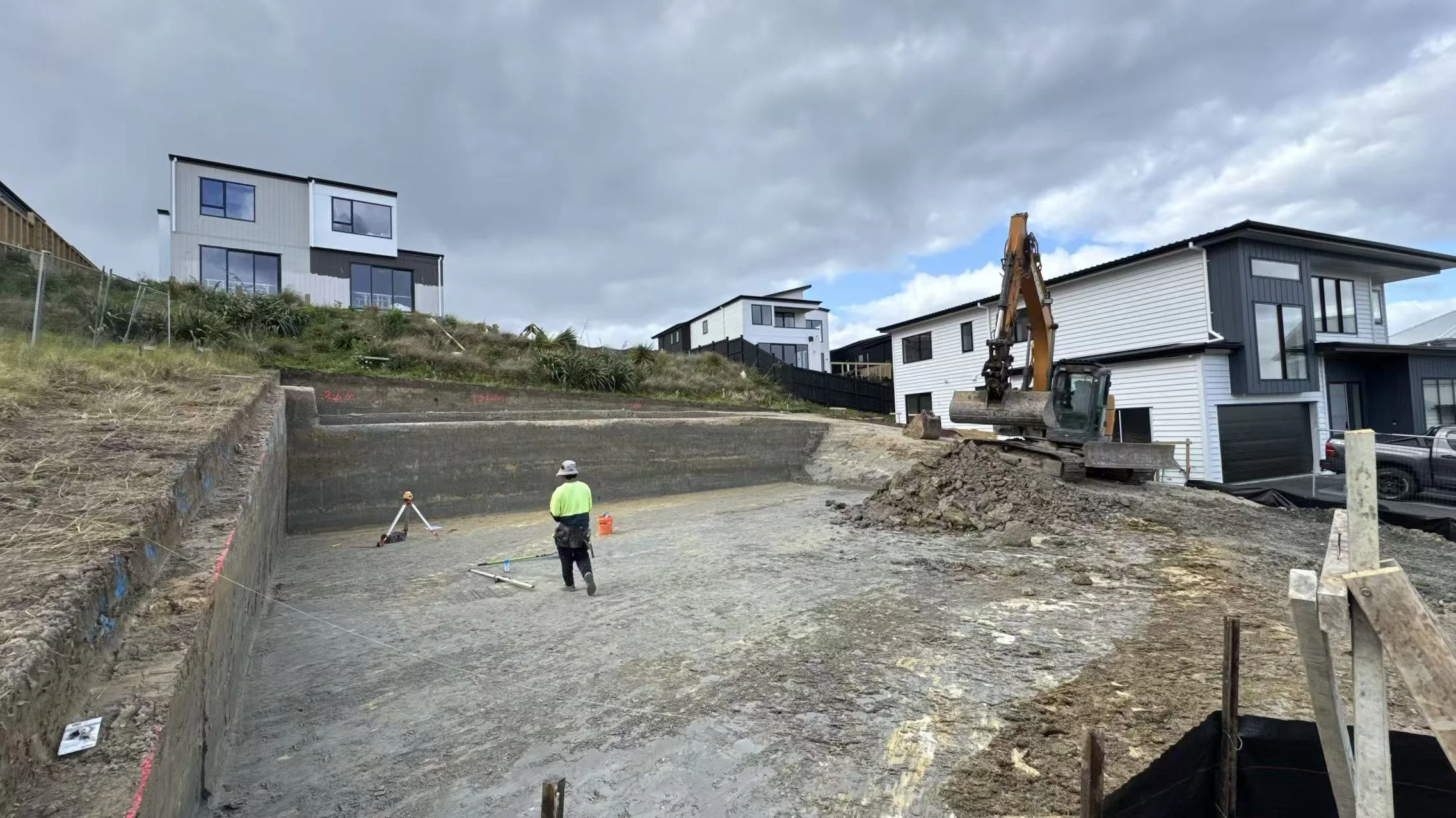 Professional site cut and ground preparation for a new residential foundation in Auckland, featuring an excavator leveling the building platform.