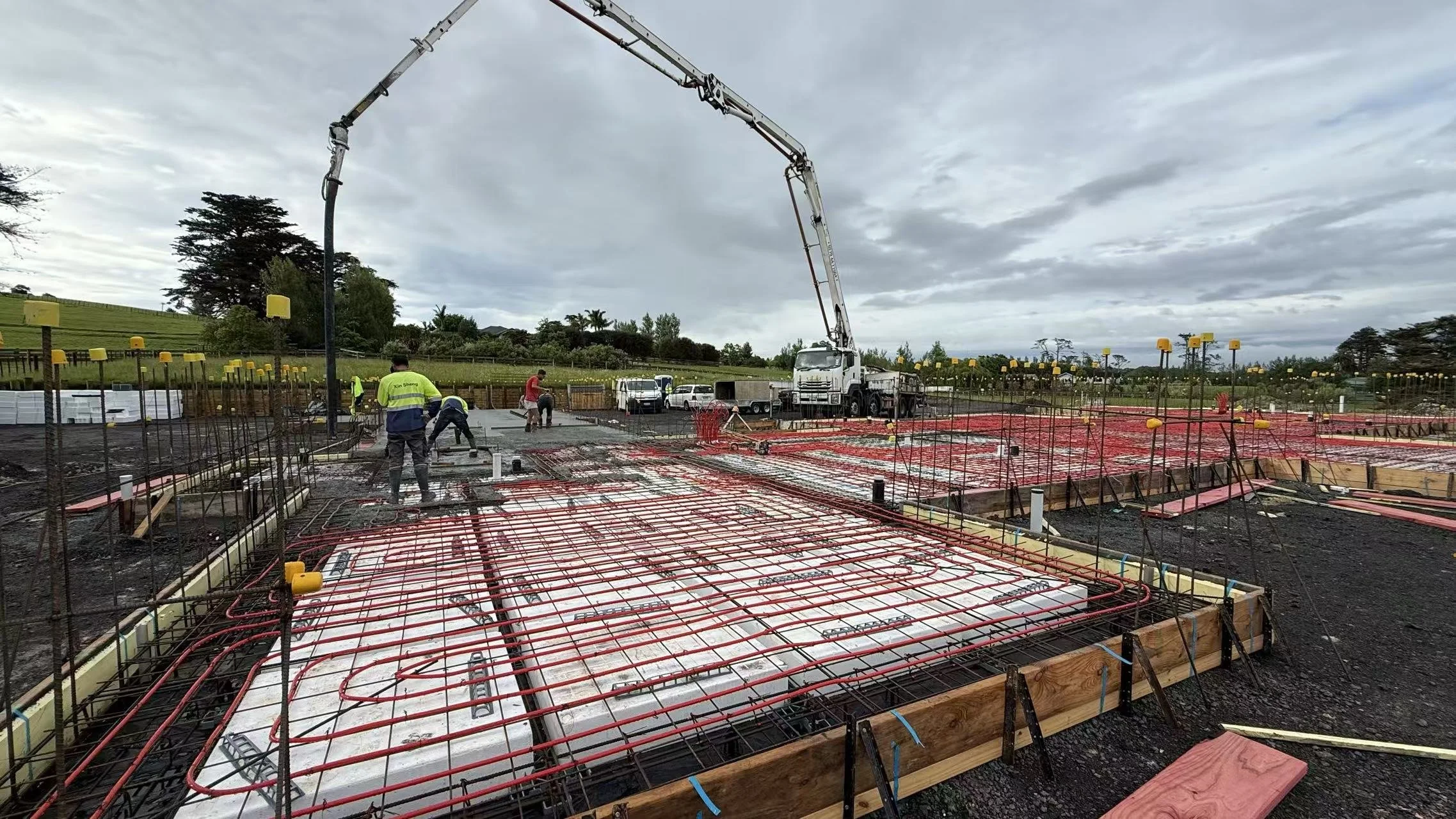 A professionally finished RibRaft foundation in Auckland, showing the completed installation of pods, steel mesh reinforcement, and the beginning of the concrete pour using a boom pump.