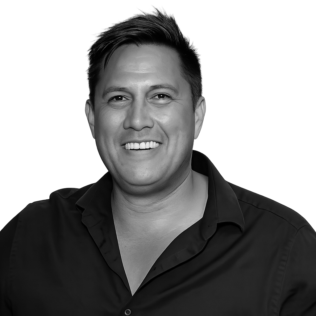 Black and white portrait of a smiling man with short hair, wearing a button-up shirt.