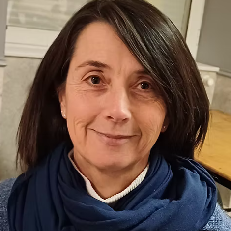 Portrait d'une femme avec des cheveux bruns, portant une écharpe bleue, souriant légèrement.