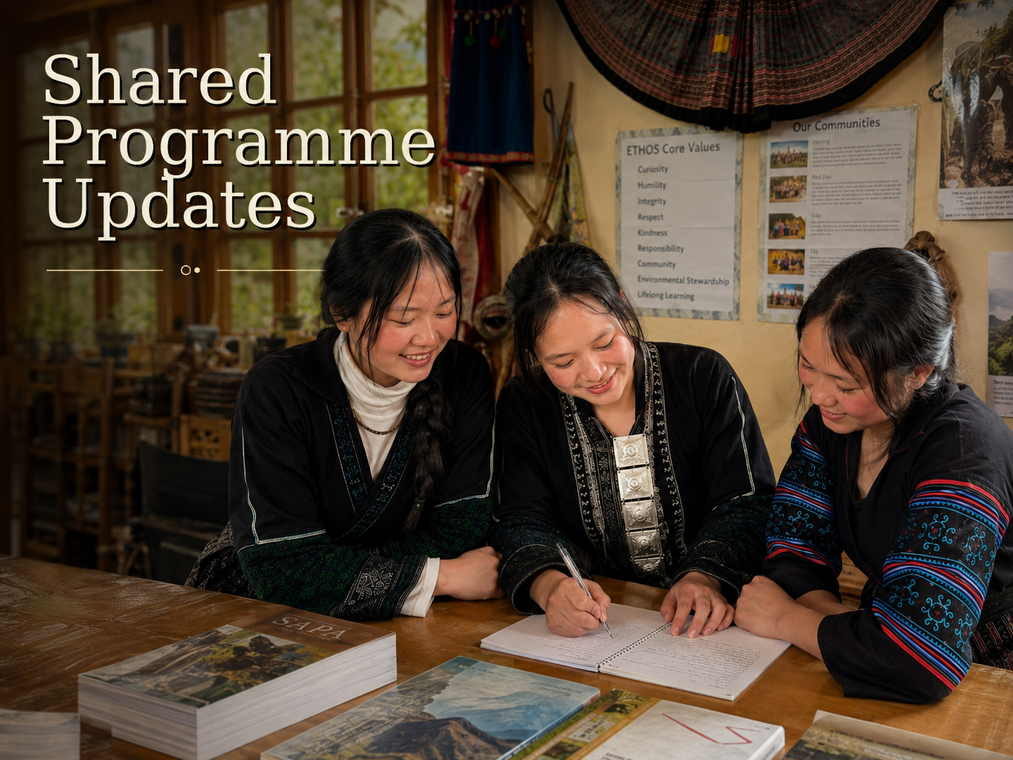 Sinh, Ta May and Pang study together at a wooden table, writing in a notebook inside the ETHOS learning space.