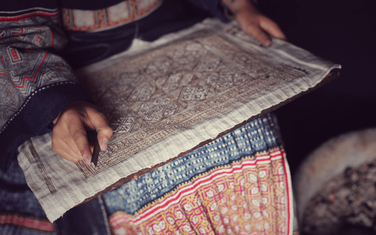 Hand-drawn geometric batik pattern on handmade hemp fabric, demonstrating traditional Hmong textile artistry.