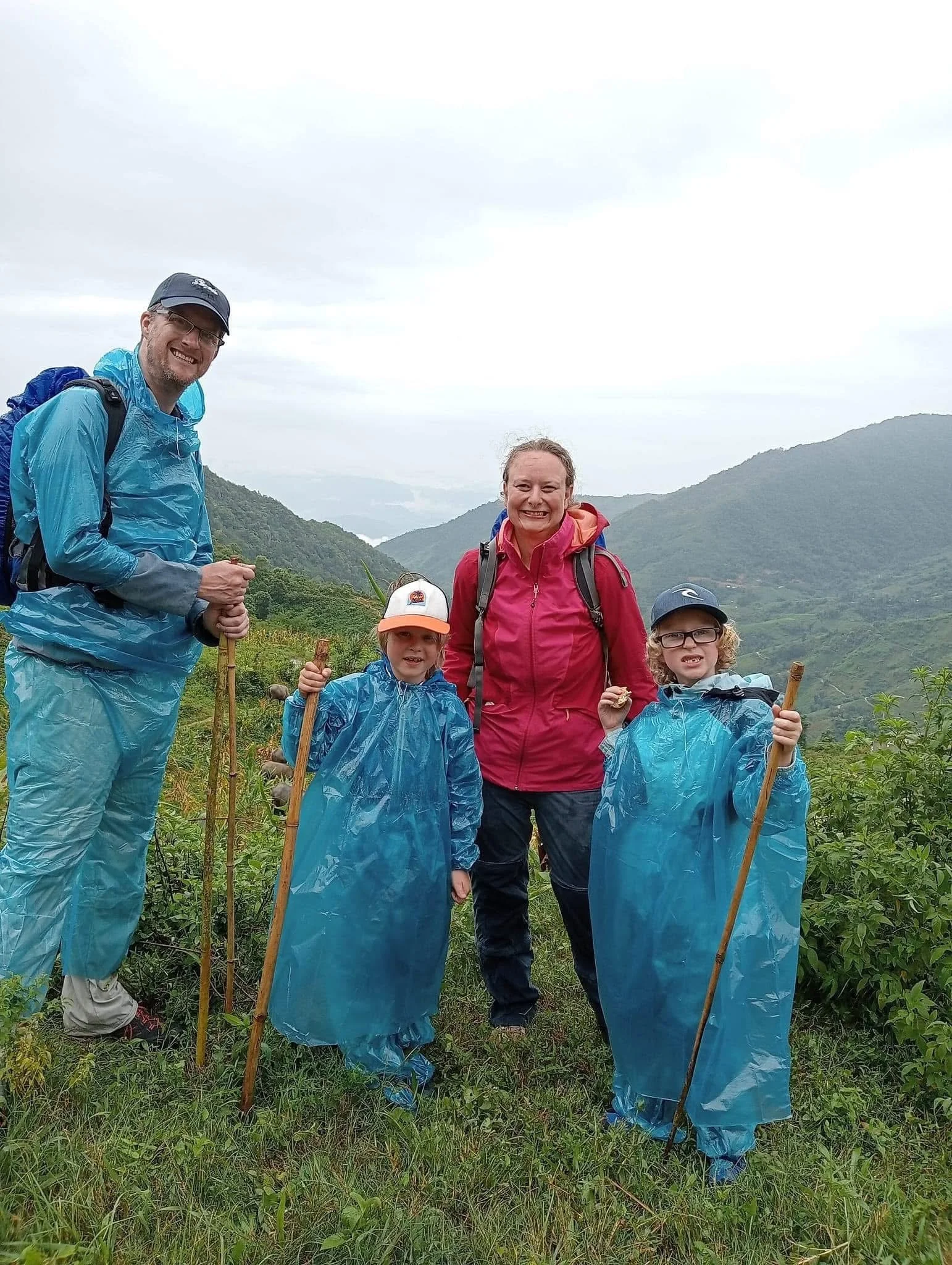 Family enjoying a trekking experience in Sa Pa, Vietnam with panoramic mountain and valley scenery.