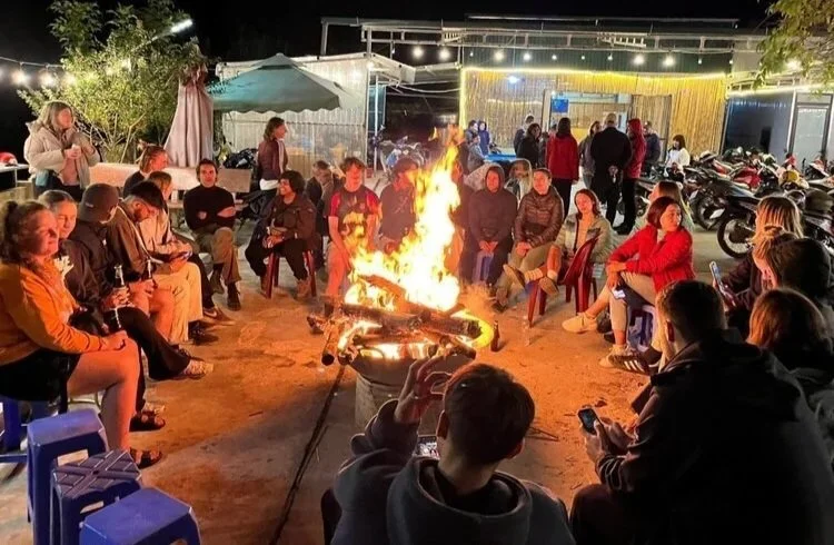 Tour group gathered around a bonfire during an evening stop on the Ha Giang Loop
