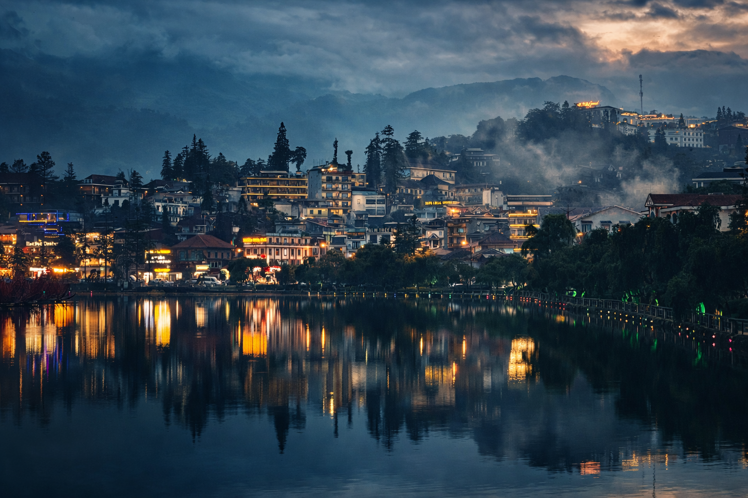 Evening view of Sapa town reflected in Sapa Lake beneath mist-covered mountains.