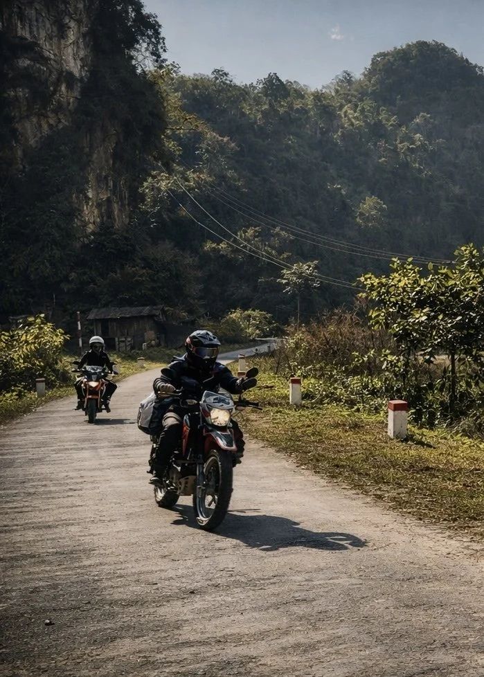 Motorbike riders travelling a rural road through the northern Vietnam highlands.